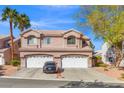 Inviting townhome featuring a tile roof, desert landscaping, dual garage and a car parked in the driveway at 5382 Runningbrook Rd, Las Vegas, NV 89120