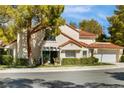 Charming home featuring a red tile roof, mature landscaping, and an attached two-car garage at 6923 Emerald Springs Ln, Las Vegas, NV 89113