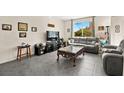Inviting living room with large windows, tile flooring, and comfortable gray sofas at 7529 Earnshaw Avenue Ct, Las Vegas, NV 89179