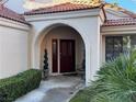 Close up view of the front entrance with a decorative arch and well-maintained greenery at 7732 Tinted Mesa Ct, Las Vegas, NV 89149
