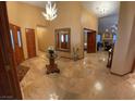 Grand foyer featuring a marble floor, elegant mirror and doorway to living room at 7732 Tinted Mesa Ct, Las Vegas, NV 89149