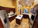 Open kitchen with dark wood cabinets, stainless steel appliances and granite countertops at 7732 Tinted Mesa Ct, Las Vegas, NV 89149