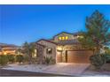 Beautiful home with a two-car garage, desert landscaping, and warm exterior lighting at 79 Rezzonico Dr, Henderson, NV 89011
