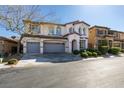 Inviting two-story home with arched windows, a three-car garage, and neatly trimmed front yard shrubs at 8743 Mount Mira Loma Ave, Las Vegas, NV 89178
