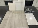 Selections of bath fixtures, cabinets, and flooring feature a chrome faucet, white cabinets, and warm gray vinyl plank at 9141 Eagle Ford St, Las Vegas, NV 89113