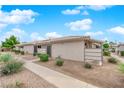 Charming single-story homes featuring stucco exteriors, desert landscaping, and a classic tile roof under a blue sky at 255 N Lamb Blvd # F, Las Vegas, NV 89110
