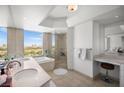 Luxurious bathroom with double sinks, soaking tub, glass-enclosed shower, and city views at 322 Karen Ave # 1507, Las Vegas, NV 89109