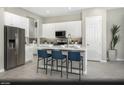 Modern kitchen with white cabinets, stainless steel appliances, an island with seating, and wood-look flooring at 325 Talladega Ct # Lot 6, Henderson, NV 89015