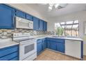 Cozy kitchen features blue cabinets, tile backsplash, and a bright window at 3365 Zephyr Ct, Las Vegas, NV 89121