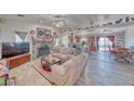 Open living room with stone fireplace, wood-look floors, and seamless flow into the adjacent kitchen at 3424 Mount Charleston Dr, Pahrump, NV 89048