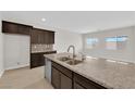 Gourmet kitchen with granite island, stainless sink, and custom cabinets, perfect for cooking and entertaining at 367 Wilford Springs St, Henderson, NV 89014