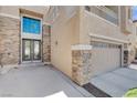 Home's exterior features a beautiful double door entry, a three-car garage and stone accents at 4129 Fabulous Finches Ave, North Las Vegas, NV 89084
