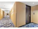 Condo hallway featuring patterned carpet, neutral walls, and modern lighting leading to unit entry door at 4381 W Flamingo Rd # 1907, Las Vegas, NV 89103