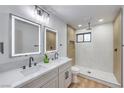 Bright bathroom boasts double sinks, lighted mirrors, and a spacious glass-enclosed shower with wood accents at 4667 E Boston Ave, Las Vegas, NV 89104