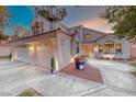 Beautiful exterior with a three-car garage, a lovely front entryway, and colorful potted flowers at 5501 Painted Sunrise Dr, Las Vegas, NV 89149