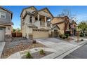 Two-story house with a balcony, two-car garage, desert landscaping, and a spacious driveway at 5829 Feral Garden St, North Las Vegas, NV 89031