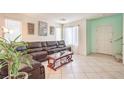 Inviting living room boasts tile flooring and a comfortable, oversized leather sectional at 6066 El Sol Dr, Las Vegas, NV 89142