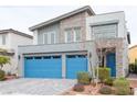 Contemporary home with blue garage doors and stone accents on the exterior facade at 618 Steep Canyon Ave, Las Vegas, NV 89183