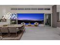 Elegant dining room with panoramic views, modern lighting, and seamless indoor-outdoor living space at 629 Majestic Rim Dr, Henderson, NV 89012
