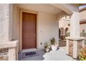 Inviting front porch with a stylish brown door and decorative stone accents at 7664 Mallard Bay Ave, Las Vegas, NV 89179