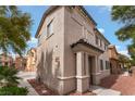 Charming two-story home with a neutral stucco finish, red stone landscaping and lovely architectural details at 7940 Violet Dawn St, Las Vegas, NV 89149