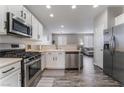 Well-equipped kitchen with stainless steel appliances, white cabinets, and a view to the living room at 7940 Violet Dawn St, Las Vegas, NV 89149