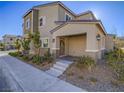 Charming townhouse with a covered porch, brick steps, and attractive landscaping for enhanced curb appeal at 10768 Ditchburn Ct, Las Vegas, NV 89166