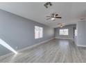 Spacious living room with modern gray floors, ceiling fan, and abundant natural light at 1334 Shimmering Glen Ave, Henderson, NV 89014