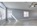 Bright living room featuring wood-look flooring, a large window, and a ceiling fan at 1334 Shimmering Glen Ave, Henderson, NV 89014