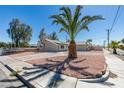 Single-story house with desert landscaping, concrete driveway and mature trees at 1900 E Oakey Blvd, Las Vegas, NV 89104