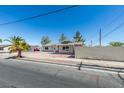 Single story house on residential street with desert landscaping, concrete driveway and mature trees at 1900 E Oakey Blvd, Las Vegas, NV 89104