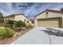 Lovely desert home with a tiled roof, palm trees, a long driveway and attached two-car garage at 2148 Shadow Canyon Dr, Henderson, NV 89044