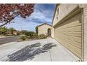 Spacious two-car garage featuring an extra long driveway and desert landscaping at 2148 Shadow Canyon Dr, Henderson, NV 89044