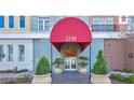 Inviting condo entrance with a vibrant red awning and manicured potted plants at 2240 Village Walk Dr # 2207, Henderson, NV 89052