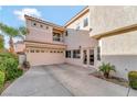 Home exterior featuring a spacious three-car garage, rear balcony, and backyard access at 2293 Bull Lake Dr, Henderson, NV 89052