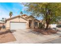 Lovely single-story home featuring mature trees, a well-manicured lawn, and a spacious two-car garage at 2410 Morocco Ave, North Las Vegas, NV 89031