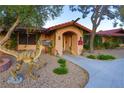 Charming single-story home with tiled roof, stucco exterior, and unique dinosaur statue in the yard at 3132 El Camino Rd, Las Vegas, NV 89146