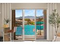 Stunning view of the waterway from a sliding glass door leading to a patio with a dock and boat at 3173 Lido Isle Ct, Las Vegas, NV 89117