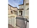 Charming gated entrance of stucco home with brick walkway and covered porch at 346 Andy Wheeler Dr, Henderson, NV 89011