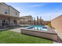 A refreshing pool and spa in a fenced backyard, complete with desert landscaping and a covered patio at 4040 Beech Fern Ave, North Las Vegas, NV 89084