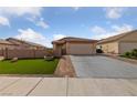 Exterior front view of a beige single-story home featuring a manicured lawn and brick paved walkway at 4611 Julesburg Dr, Las Vegas, NV 89139