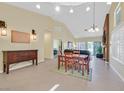 Spacious dining and living area featuring tiled floor, vaulted ceiling, and modern lighting fixtures at 4932 Forest Oaks Dr, Las Vegas, NV 89149