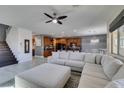 Spacious living room featuring a modern ceiling fan and seamlessly flowing into the open-concept kitchen with an island at 4982 Mountain Pepper Dr, Las Vegas, NV 89148