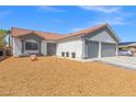 Single-story home with a terra cotta roof, two-car garage, and desert-friendly front yard landscaping at 5227 Zebra Ct, North Las Vegas, NV 89031