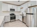 Well-lit kitchen with stainless steel appliances and modern white cabinets and light countertops at 5415 W Harmon Ave # 1074, Las Vegas, NV 89103