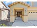 Inviting covered porch with decorative columns, lighting and concrete path to the two-car garage at 5808 Sierra Cliff St, North Las Vegas, NV 89031