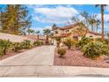 Beautiful two-story home featuring desert landscaping, long driveway, and mature palm trees at 650 Hermosa Palms Ave, Las Vegas, NV 89123