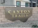 Canyon Trails sign in gold letters mounted on a brick and rock wall, showcasing community entrance at 9362 Soothing Sea St # Lot 84, Las Vegas, NV 89178