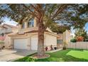 Well maintained two-story home with a large tree, lawn and three-car garage at 947 Rainbow Rock St, Las Vegas, NV 89123