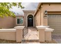 Close-up view of a home's entry featuring a decorative stone archway and manicured landscaping at 9731 Addie Meadow Ct, Las Vegas, NV 89149